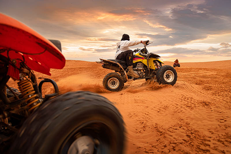 A group of people quad biking on the Red Sand Dunes wisata arab saudi